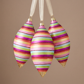 Boule de Noël Pop Allongée à Rayures et Paillettes Rouges fuchsia en verre, packshot fond beige