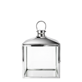 Lanterne large en métal brillant argenté avec anse arrondie, dessus en pente et avec fenêtres transparentes en verre. Acier inoxydable.