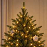 Vue rapprochée du feuillage vert très dense du sapin Fluffy 150 cm éclairé par ses LED blanc chaud