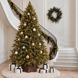 Très grand sapin de Noël lumineux Fluffy vert 300 cm allumé au pied d'un escalier avec cadeaux