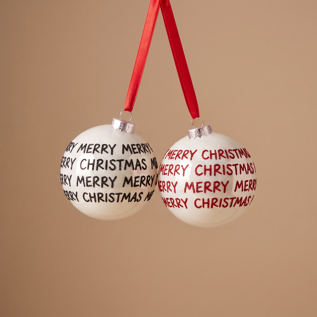 Boules de Noël Graphiques Merry Christmas blanc en verre, packshot fond beige