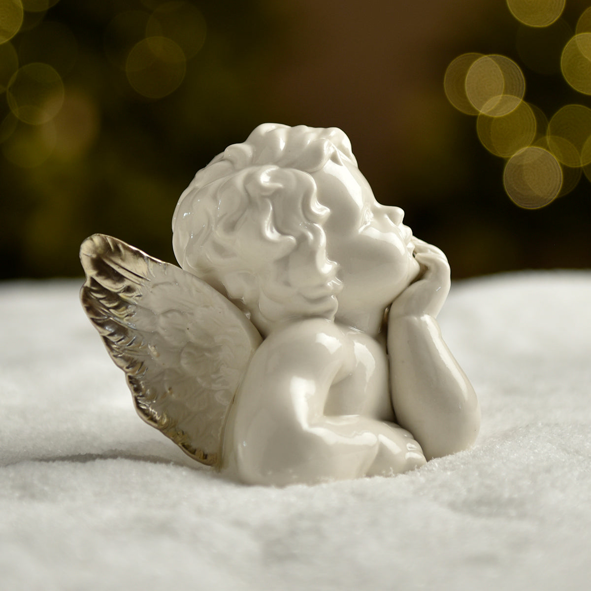 Statuetta di angelo alato che si tiene il mento in una mano