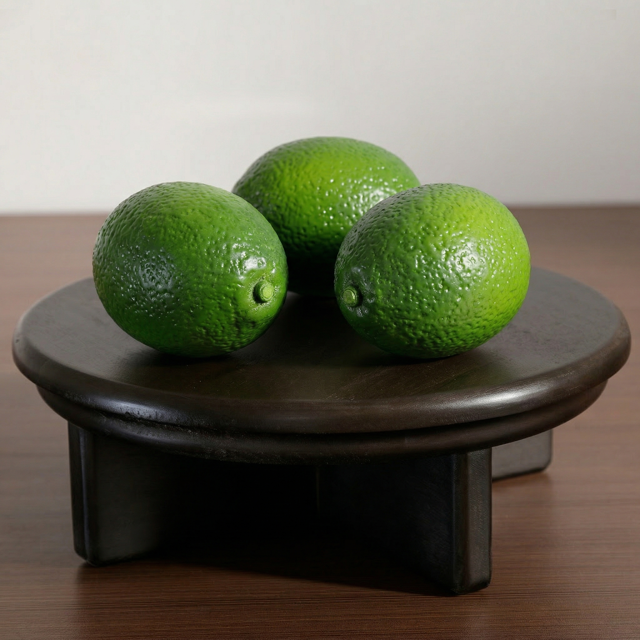 Citron verts artificiels Sia Deco sur plateau noir en bois