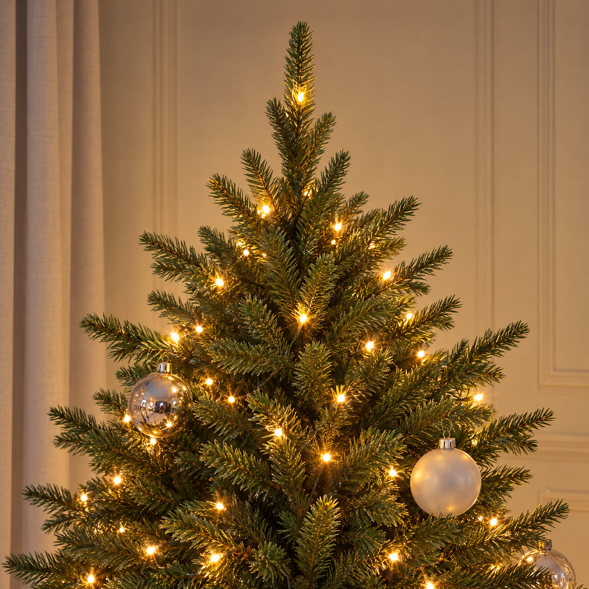Vue rapprochée du feuillage vert très dense du sapin Fluffy 150 cm éclairé par ses LED blanc chaud