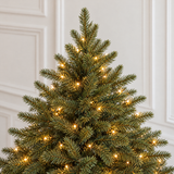 Vue rapprochée du feuillage vert très dense du sapin Fluffy 250 cm éclairé par ses LED blanc chaud