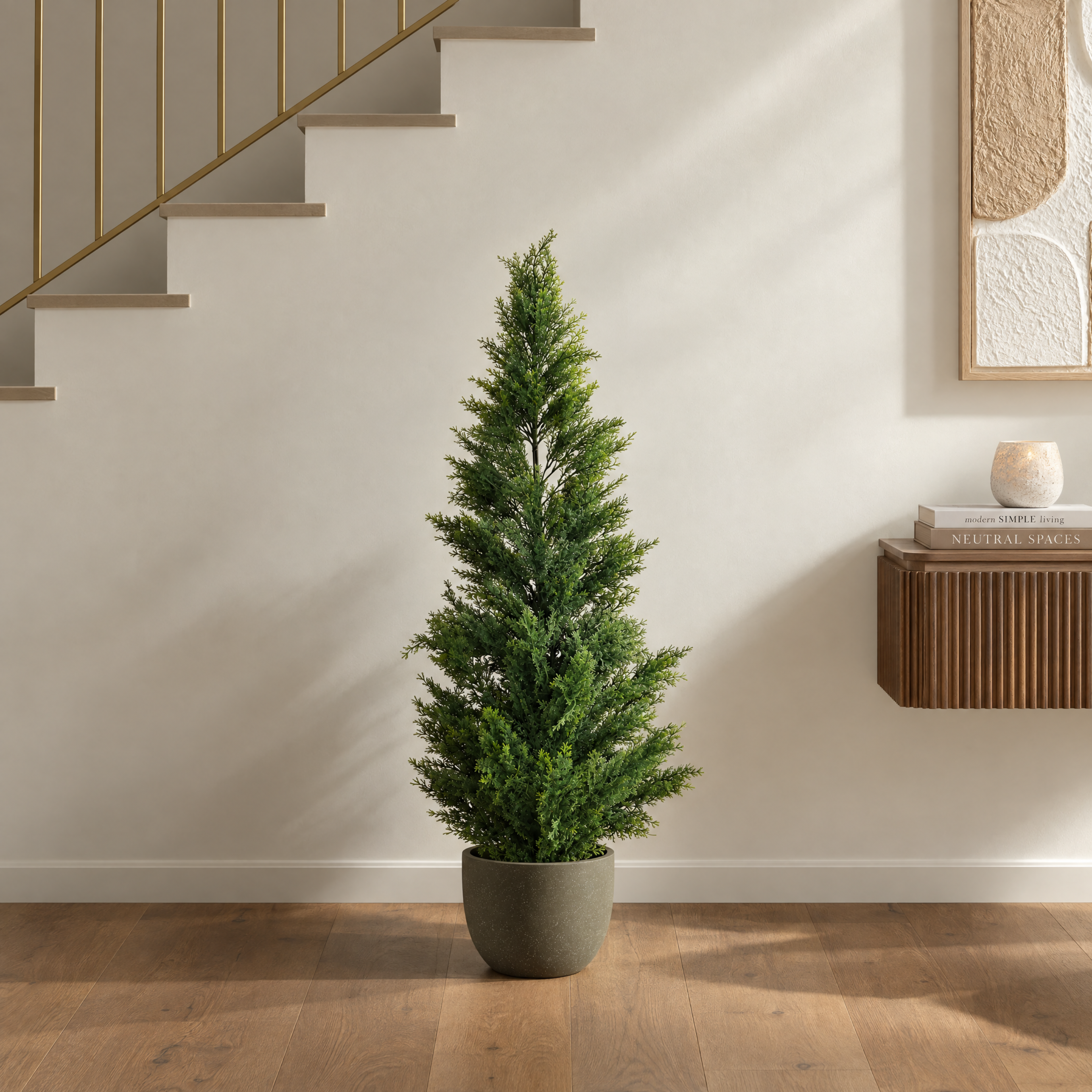 Cyprès artificiel 120 cm en pot posé au sol dans une entrée contemporaine beige, près d'un escalier et d'une console en bois